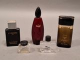 three perfume bottles and a lighter on a white surface