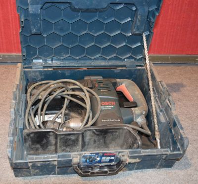 une boîte à outils contenant une perceuse filaire et un cordon d'alimentation