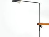black and white lamp on a wooden table against a white wall