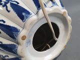a blue and white vase with a handle on a table