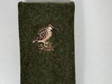 a small bird embroidered on the side of a green bag