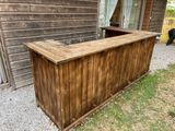 a wooden bar sitting outside of a wooden building