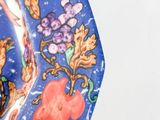 a blue plate with a design of flowers and birds on it