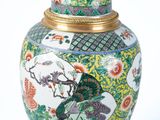 a vase with a bird and flowers on it on a white surface