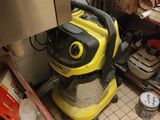 un aspirateur jaune et noir posé par terre dans une cuisine