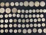 a large collection of silver coins on a black background