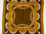 une photo d'une écharpe carrée marron et blanche ornée d'un motif décoratif