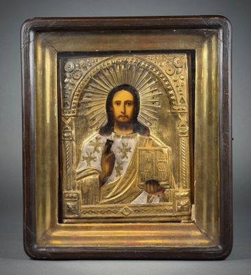 a gold - plated icon of jesus holding a book