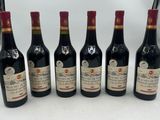 six bouteilles de vin sont alignées sur une table