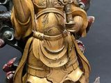 a gold statue of a person holding a bowl