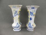 two vases that have been painted with blue and yellow designs