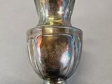 a silver vase that is sitting on a table
