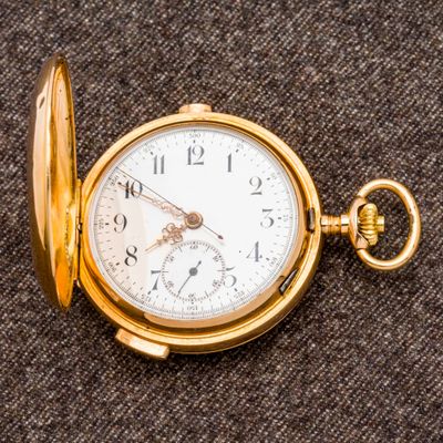 un gros plan d'une montre de poche posée sur un tissu