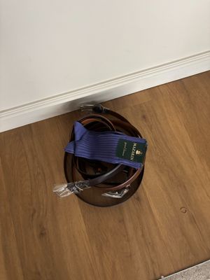 une photo montrant une paire de chaussures et une ceinture posées par terre