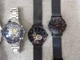 three different watches sitting on a table next to each other