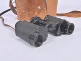 an old pair of binoculars sitting on top of a brown bag