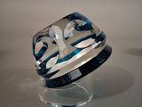 a blue and white glass ring on a clear stand