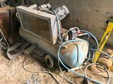 a small air compressor sitting on the ground next to a pile of tools