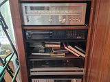 a tall wooden cabinet with many electronics on top of it