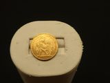 a gold coin sitting on top of a white object