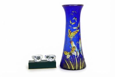 un vase bleu orné d'un motif de poisson rouge, à côté d'une bague en diamant