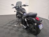 a black motorcycle that is parked on a checkered floor