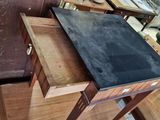a table with a black slate top in the middle of a room