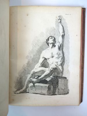un vieux livre sur lequel figure le dessin d'un homme assis sur un banc