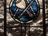 a stained glass window in the corner of a stone wall