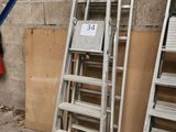 beaucoup d'échelles empilées contre un mur