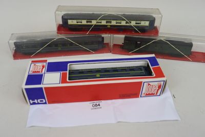 trois trains miniatures se trouvent dans une boîte posée sur une surface blanche