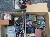 two boxes full of electronic devices sitting on the ground