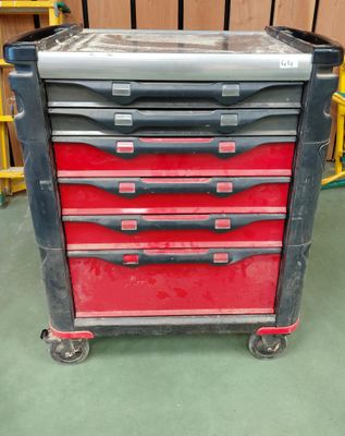 une boîte à outils rouge et noire sur roulettes dans une pièce
