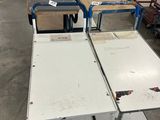 de nombreuses tables et chariots dans un entrepôt, sur lesquels sont empilés de nombreux cartons