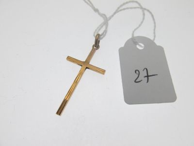 un gros plan sur une croix et une étiquette de prix posés sur une table