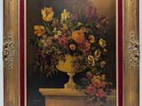 painting of a vase of flowers in a gold frame on a white wall