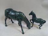 two figurines of a horse and a foal on a table