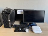 un ordinateur de bureau posé sur une table à côté d'un clavier et d'une souris