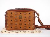 a brown cross body bag sitting on top of a white surface