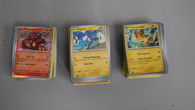 trois cartes pokemon posées les unes sur les autres sur une table