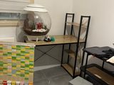 a room with a desk, a chair, and a fish bowl