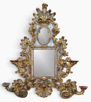 un miroir accroché au mur à côté d'une applique