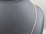 a close up of a gold chain necklace on a mannequin