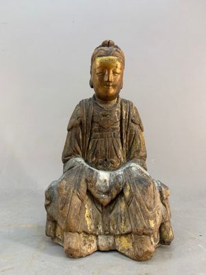 statue of a woman sitting on a rock with her hands in her lap