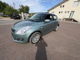 the small green car is parked in the parking lot