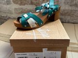 green and white sandals on a cardboard box on top of a cardboard box