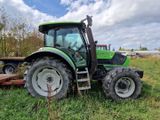 un tracteur vert garé dans l'herbe
