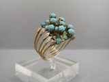 une photo en gros plan d'une bague sertie de pierres de turquoise