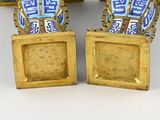 pair of blue and white vases sitting on top of a table