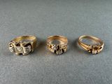 three different types of gold rings on a table